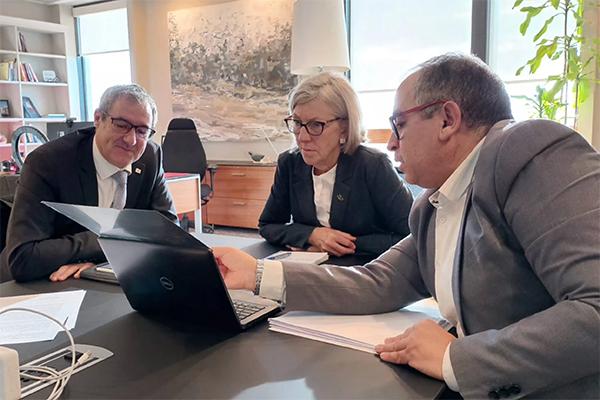 three executives looking at a laptop together
