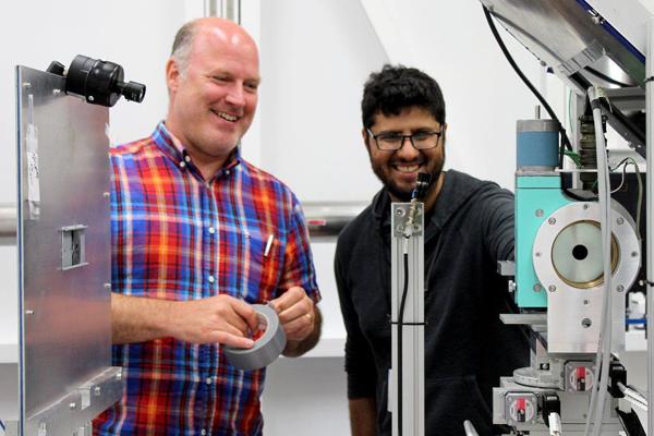 two scientists working on equipment in the lab