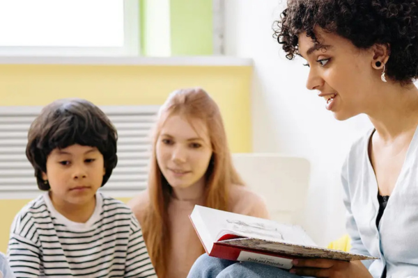 A person reading a story to a group of young children.