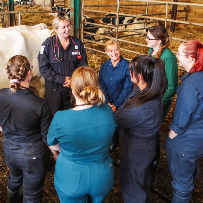 students gathered around a teacher in a barn