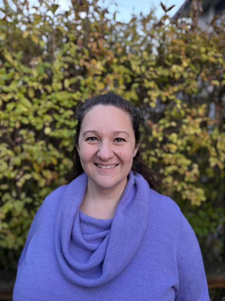 Photo of woman standing outside, blue sweater