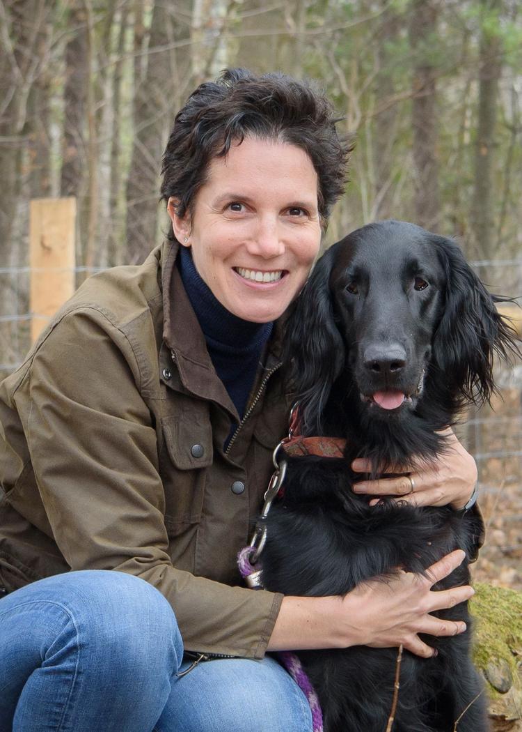Alice Defarges head and torso shot, with her holding her dog Stan