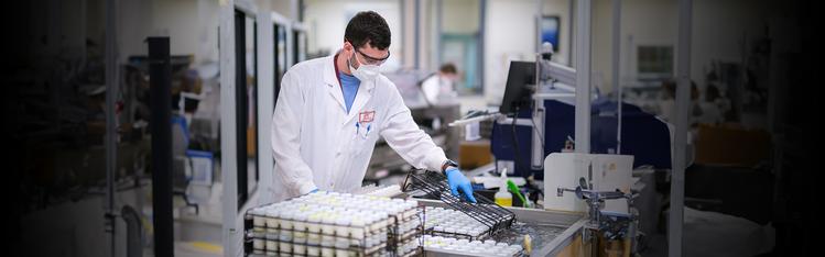 Lab staff standing over milk samples preparing them for testing.