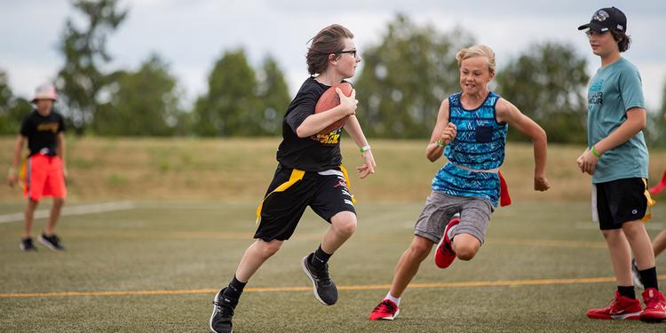 A group of youth playing flag football outside.