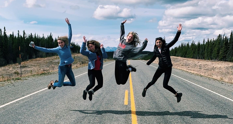 Four happy students pose for the camera during a field trip