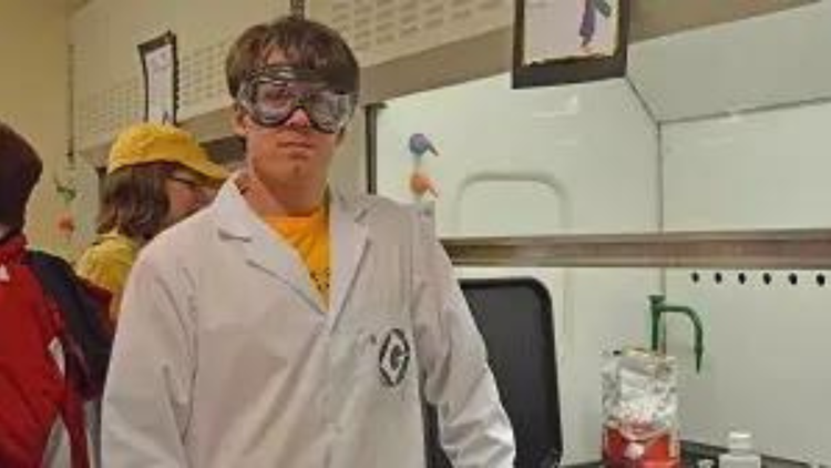 Student in a lab coat and goggles.