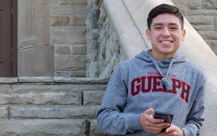 A U of G student holding a phone