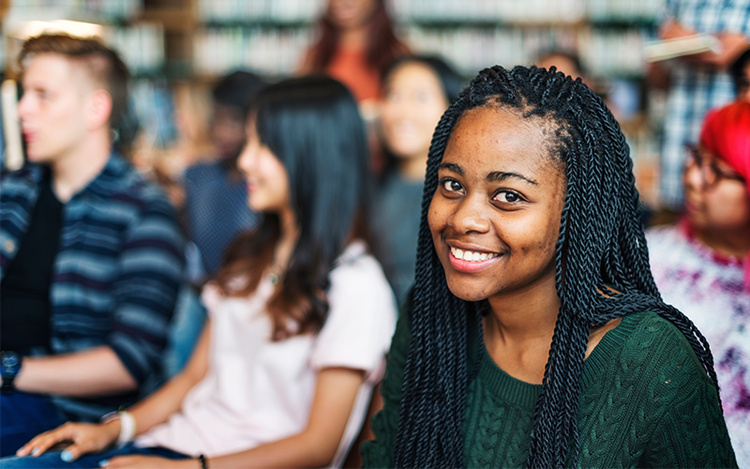 Students smiles at the camera during a seminar