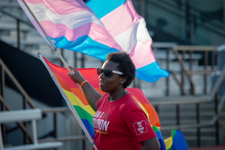 Person holding pride flags.