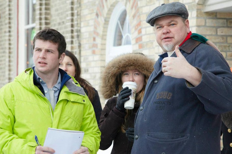 Community planner shows group of students around a rural town in winter
