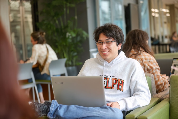 Male student sitting with a laptop
