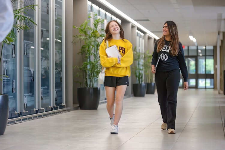 2 female students walking toward the camera