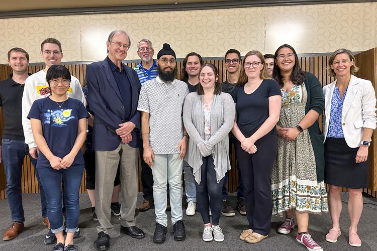 Image of Dr. Peter Tremaine standing with talk attendees