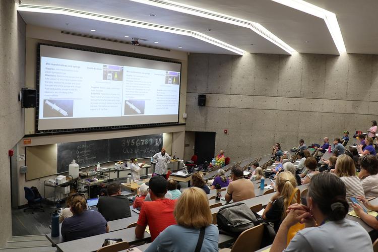 A large group watch a demonstration at ChemEd 2023