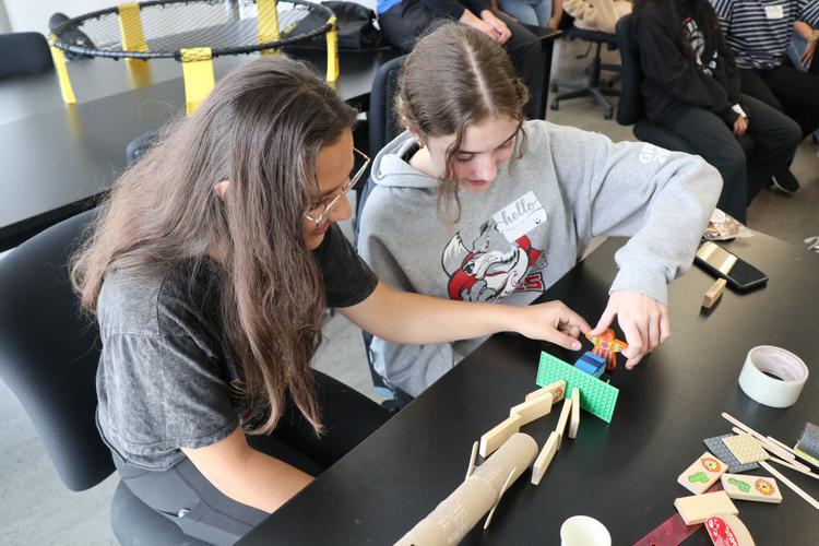 Two youth work together at an outreach event in 2023