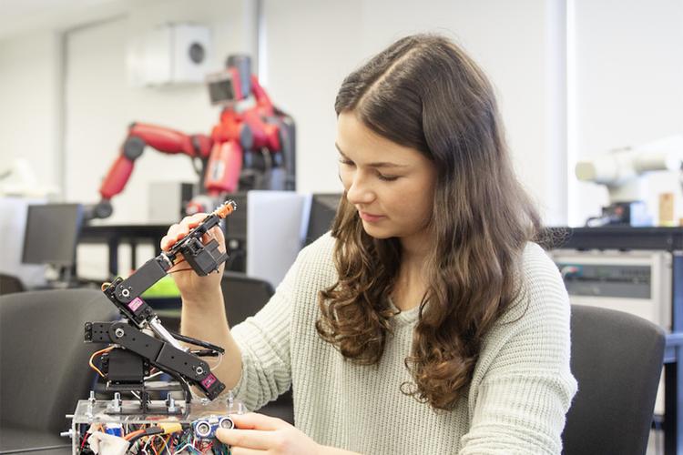 female student in a STEM class working with robots