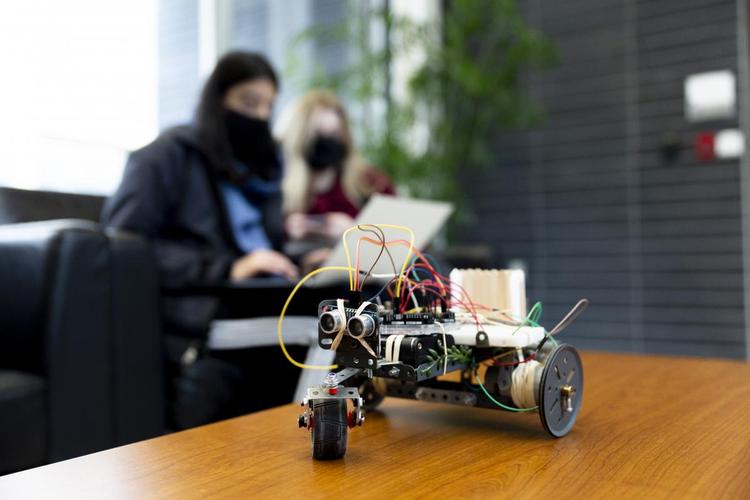 a vehicle design with 2 students in the background