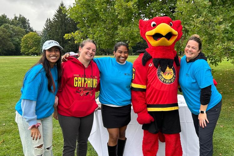 U of G staff pose with Gryph as a part of a wellness event.