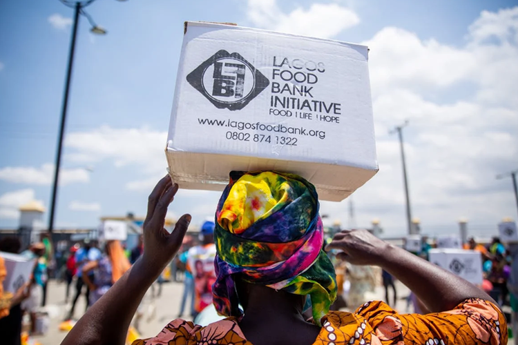a person with a box of food resting on the top of their head. the box reads lagos food bank initiative