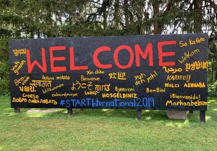 Welcome in many languages painted on a sign