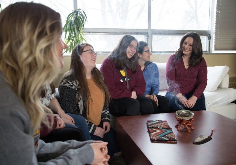 Students sitting on couch smudging