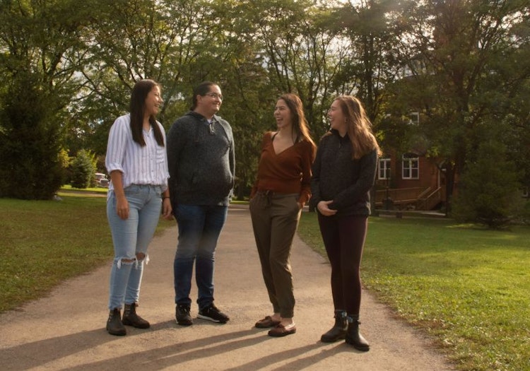 four indigenous students talking and laughing outside