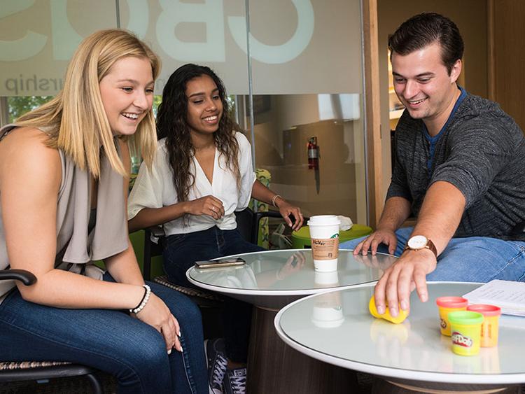 3 University of Guelph students at a cafe playing with play-doh