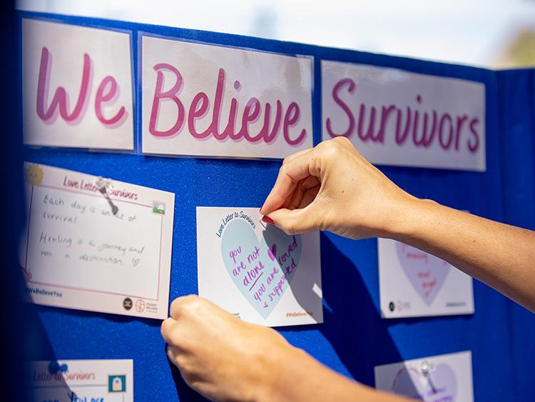 Hands adding card to the Cork Board