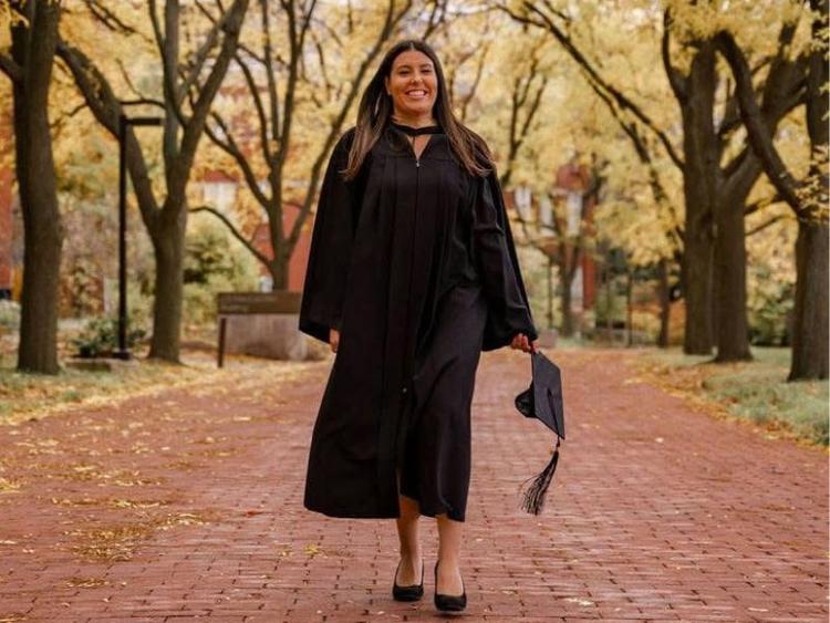 Jessica Seifried walking on U of G campus in her grad gown.