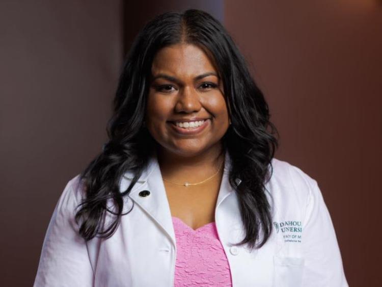 U of G grad Dr. Naythrah Thevathasan wearing a lab coat