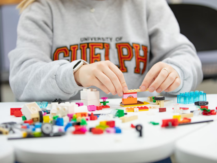 Image of a student working with lego wearing a University of Guelph crewneck