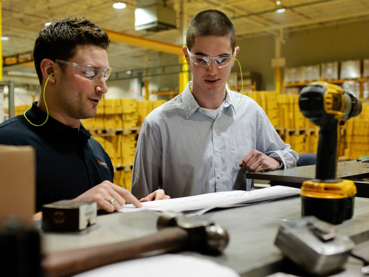 two engineers read paper in warehouse