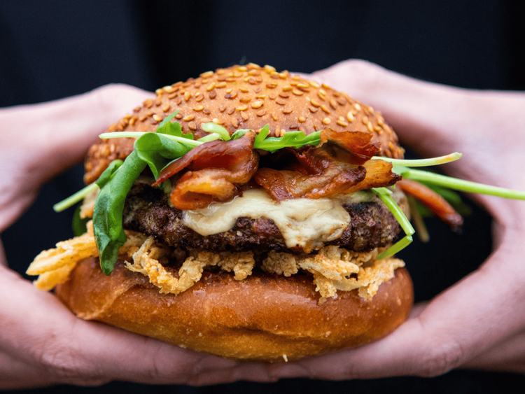 Golden Gryphon Burger held in hands