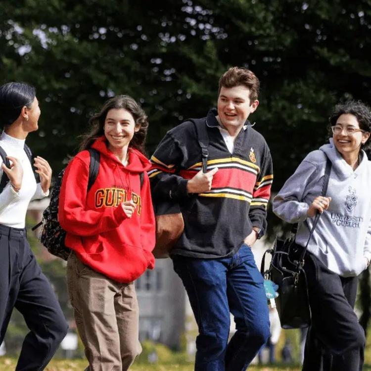 U of G students smiling and talking while walking on campus