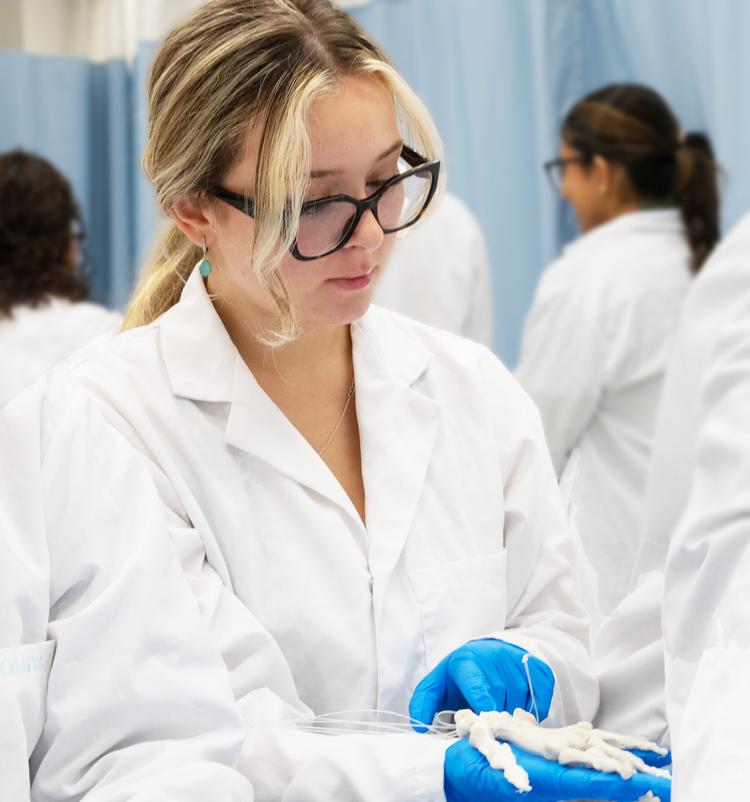 Student holding a skeleton hand