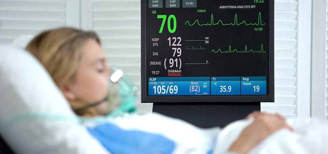 Patient resting in a hospital bed with a monitor (iStock credit Motortion)