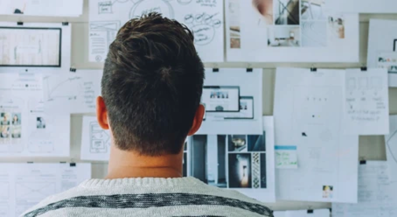 student looking at board with notes