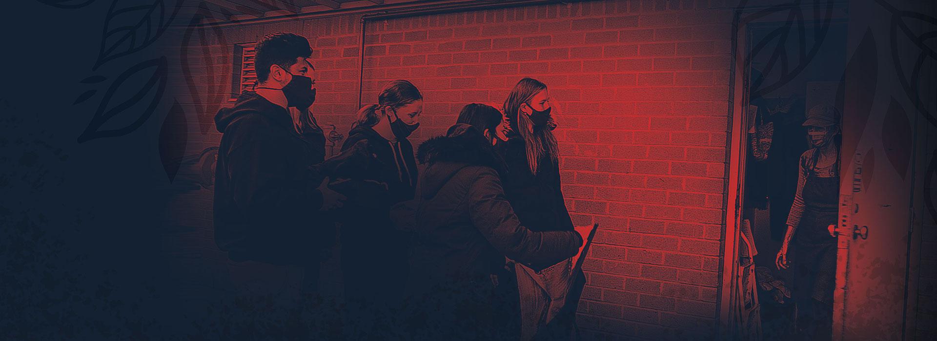 Students in a line beside a brick wall