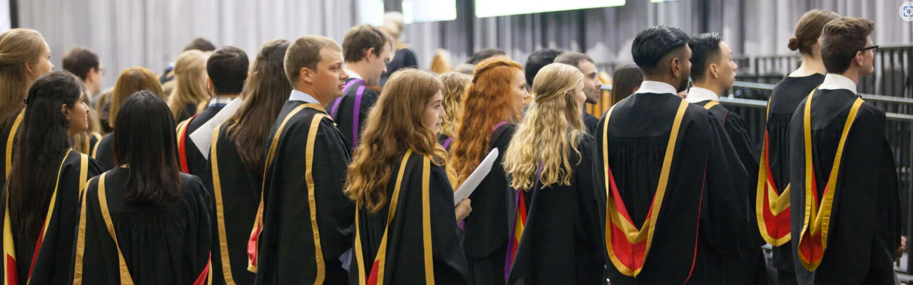 A group of University of Guelph graduates are pictures wearing ceremonial convocation robes.