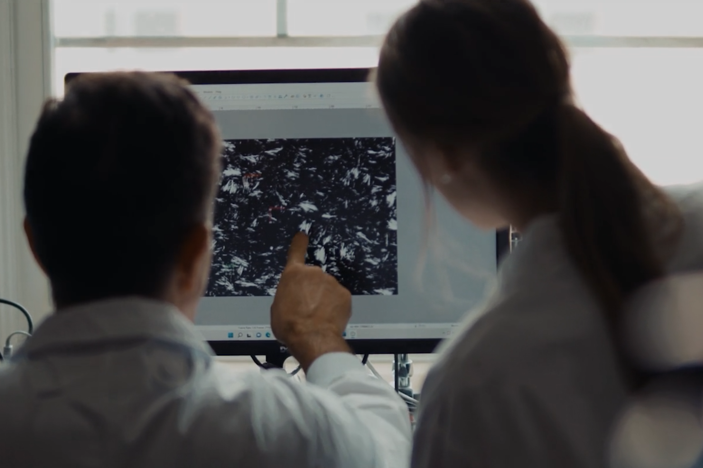 U of G students in a lab pointing at a computer screen