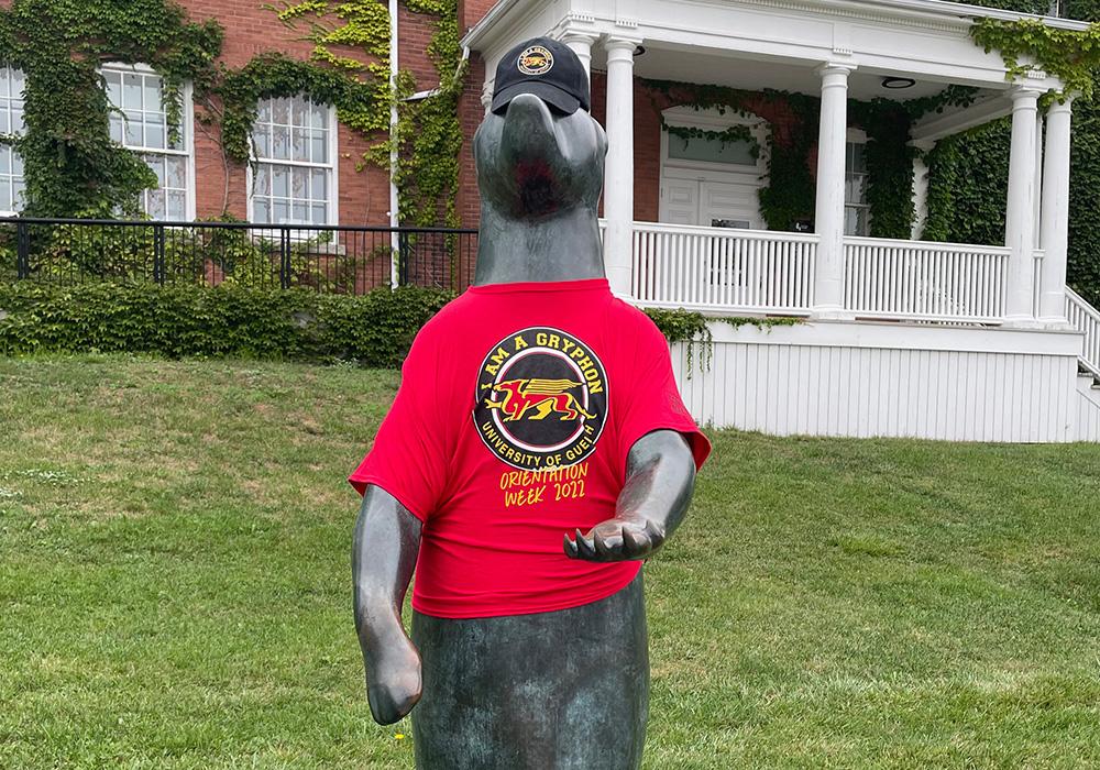 begging bear dressed in red Orientation Volunteer shirt 2022 and hat