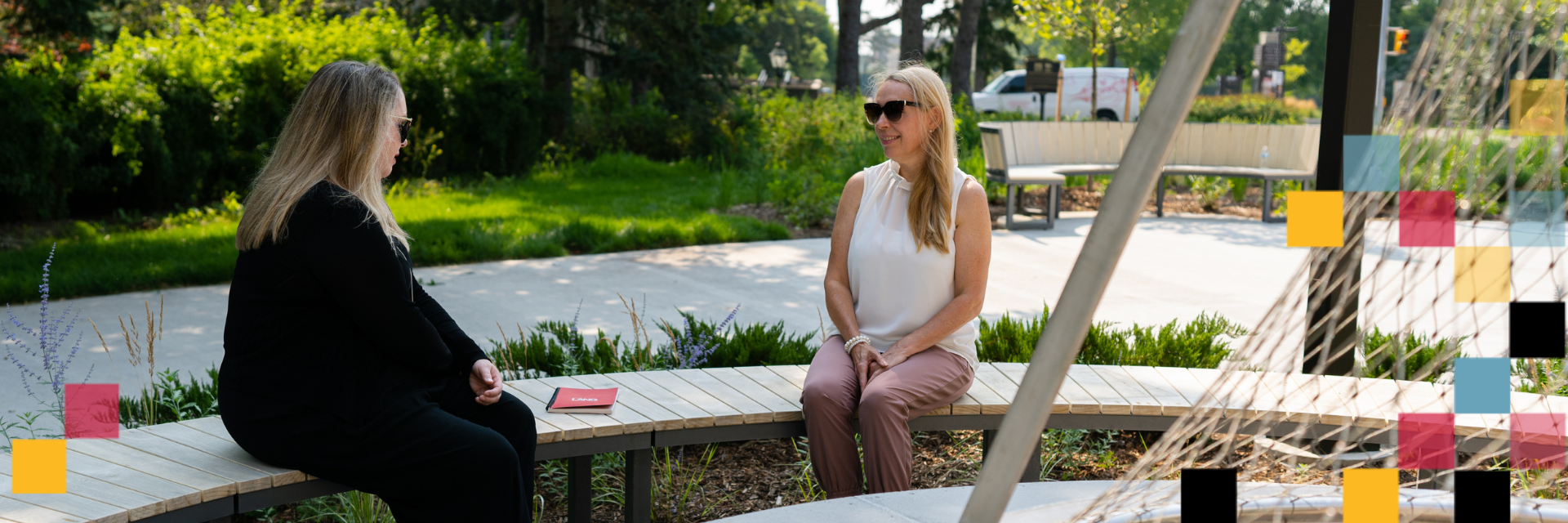 Two people sitting by the fire pit in Lang Plaza.