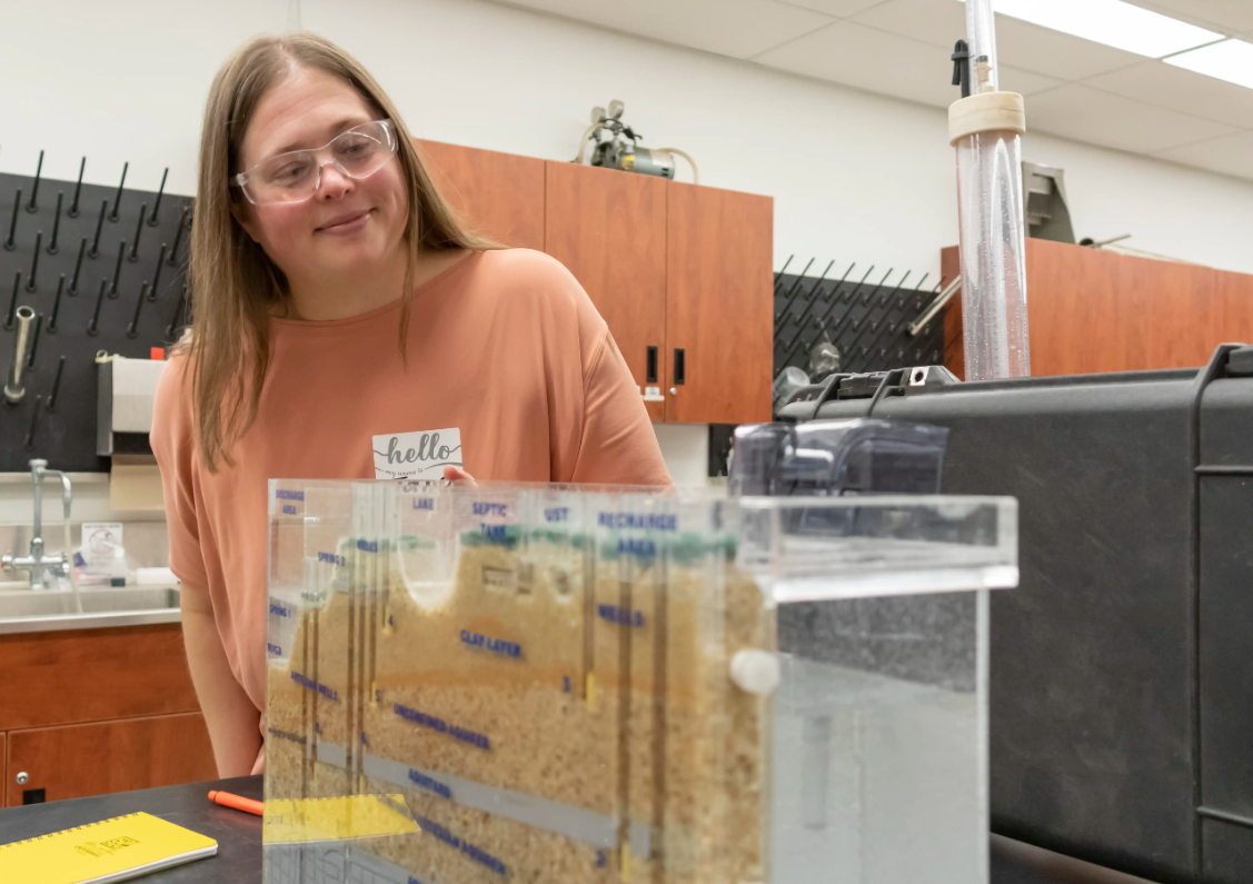 Jana Levison, PhD, P.Eng. looking at a soil purifying equipment. 