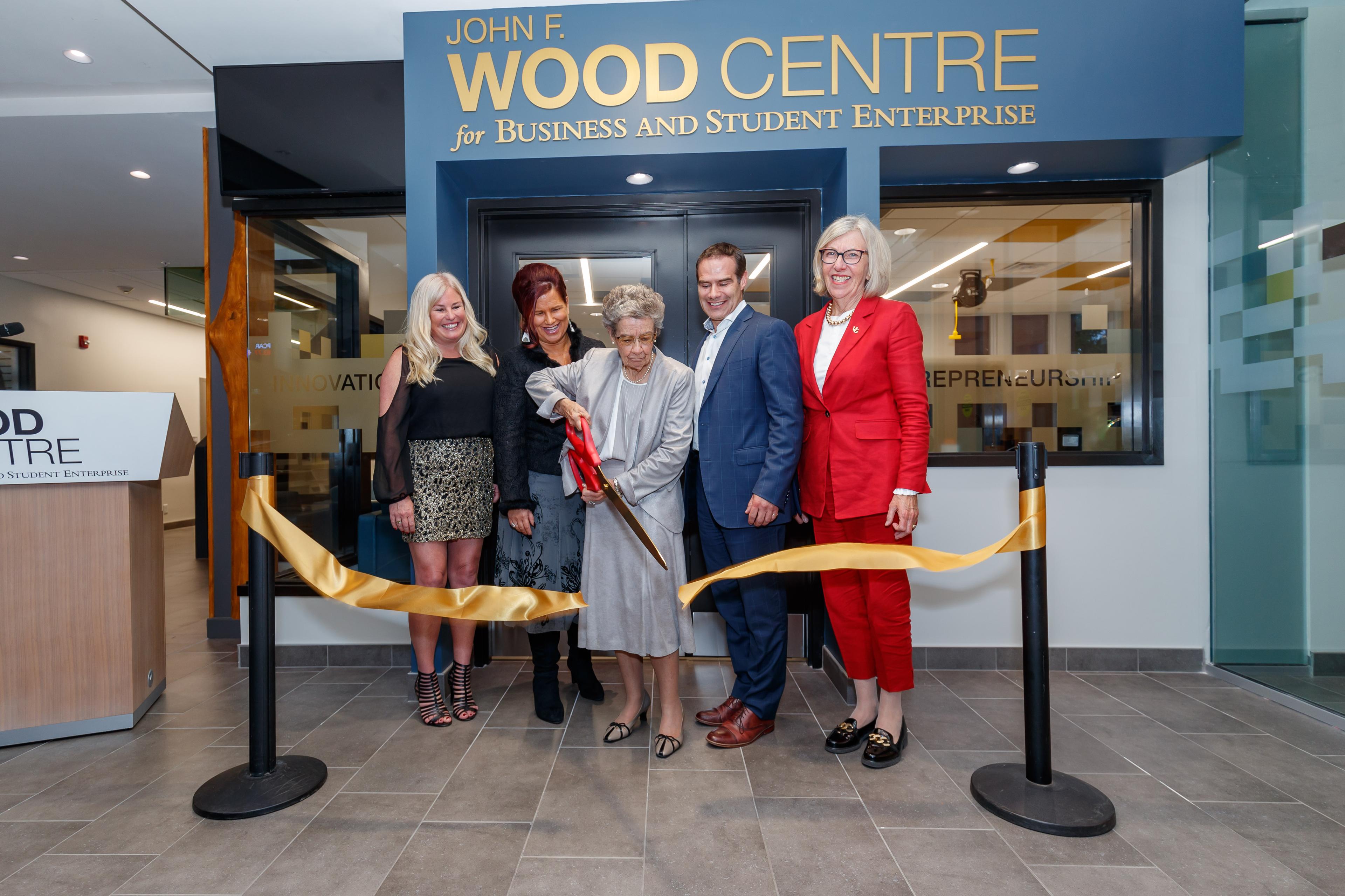 5 people cutting a ribbon 