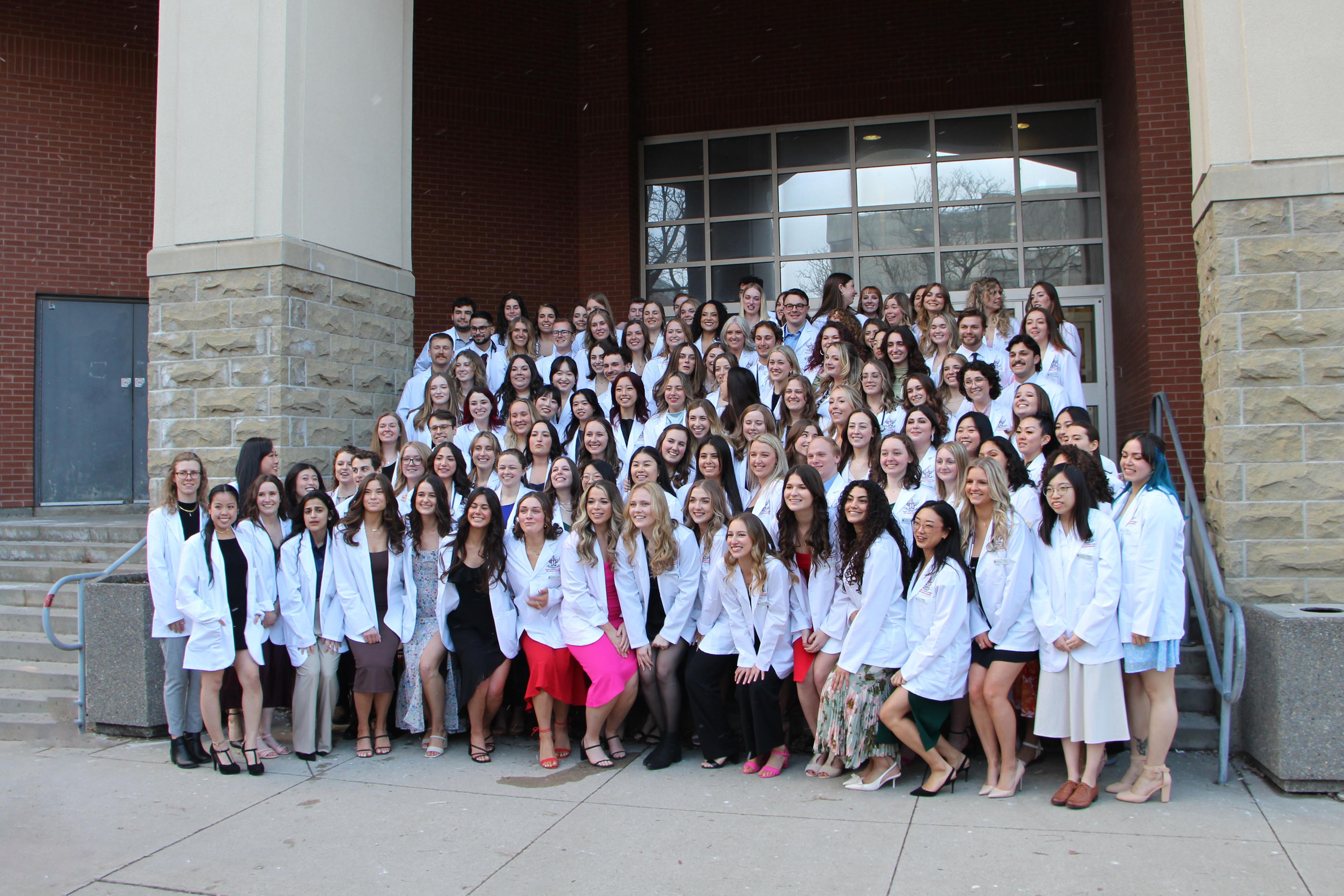 The Ontario Veterinary College's (OVC) Doctor of Veterinary Medicine (DVM) Class of 2025 gather for a photo on the University of Guelph campus after receiving their white coats. 