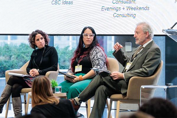 panel of 3 people sitting while one is talking and the others listen