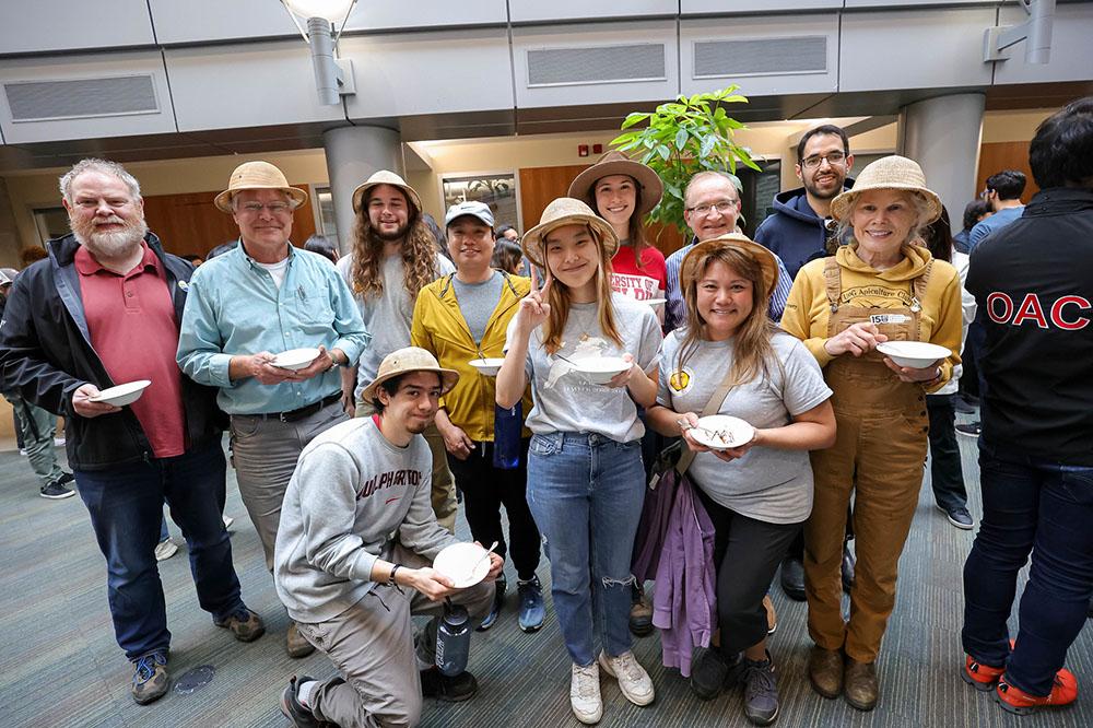 A diverse group of 11 people posing with their ice cream.