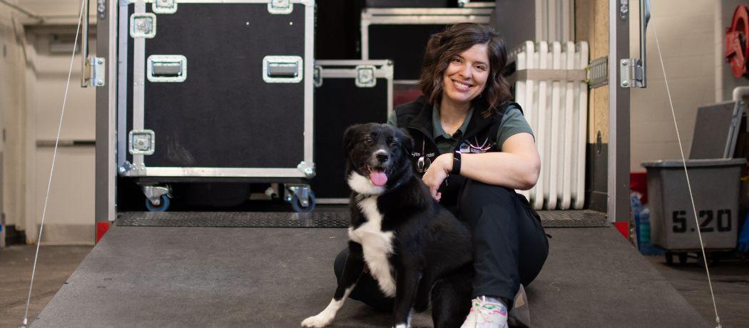 Dr. Lynn Henderson sits in front of the open CHPP trailer with her dog Violet.