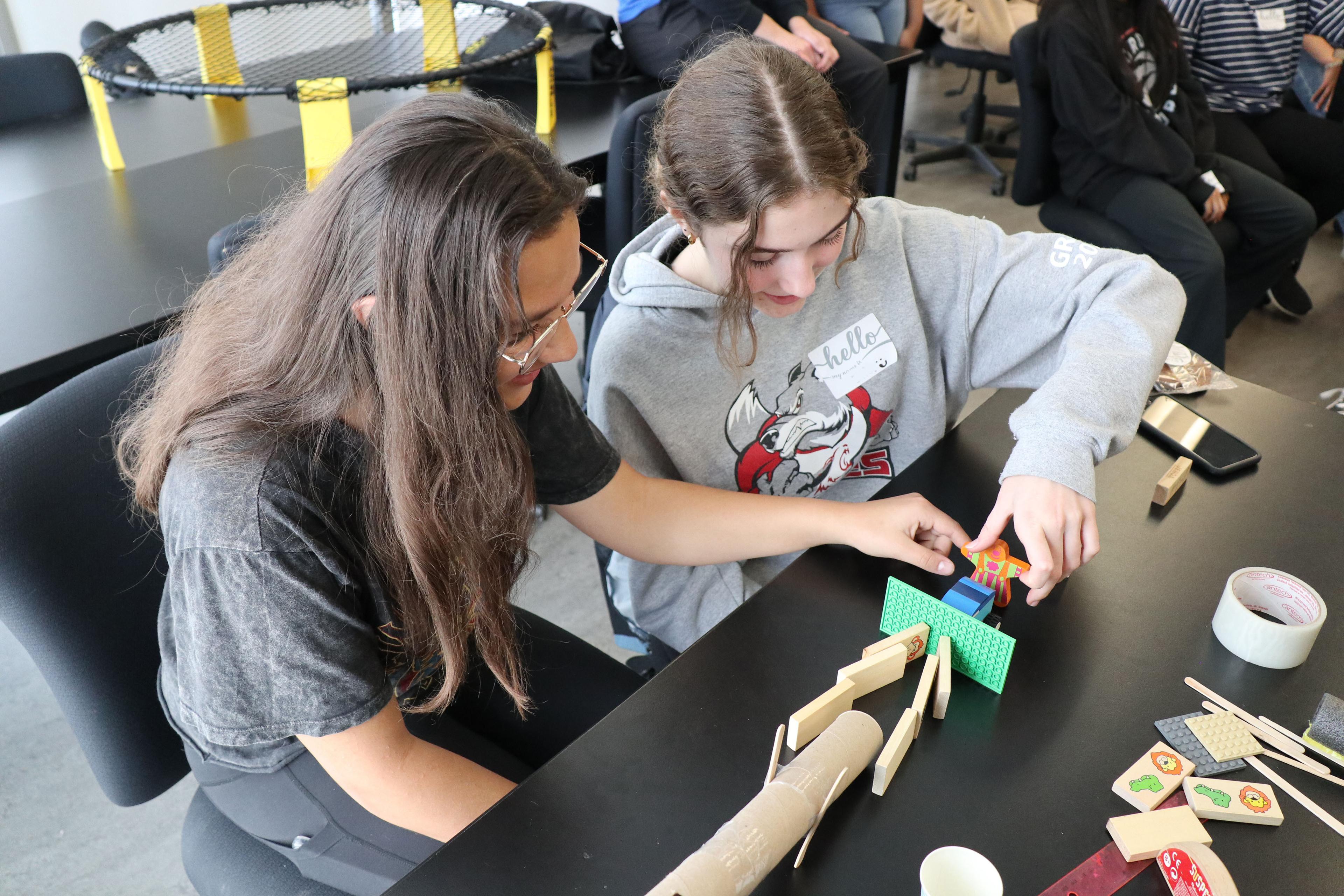 Two youth work together at an outreach event in 2023