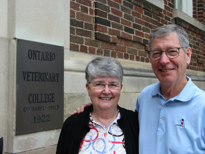 man and woman next to building plaque